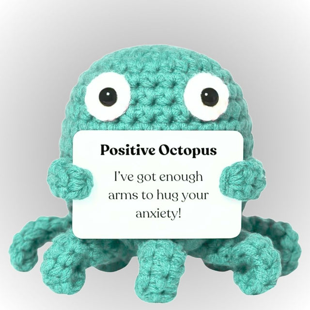 Crocheted teal octopus plush holding a sign with text on a light gray background. Positive octopus emotional support plush gift cute small turquoise crochet octopus holding affirmative message gift for boyfriend girlfriend